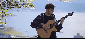 男子树下吉他乐器演奏视频素材