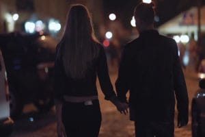 夜色街道上牵手行走的情侣